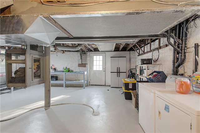 basement with electric panel and washer and clothes dryer