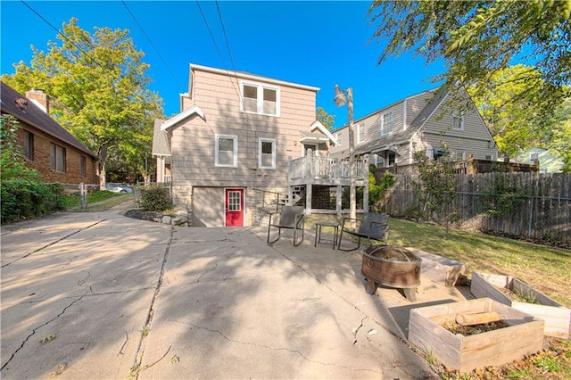 back of property with a fire pit, a yard, and a patio area