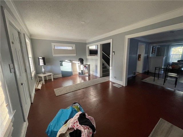 interior space with ornamental molding, dark wood-type flooring, and a textured ceiling