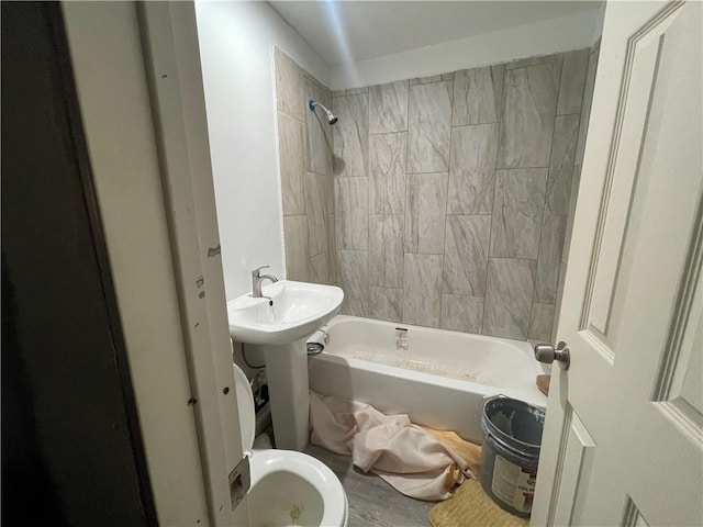 bathroom featuring tiled shower / bath and toilet