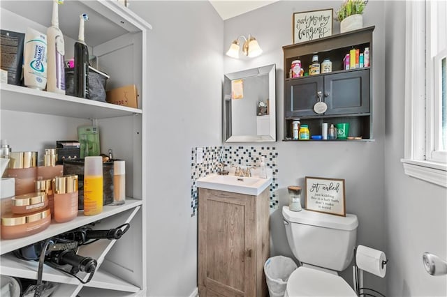 bathroom with decorative backsplash, toilet, and vanity