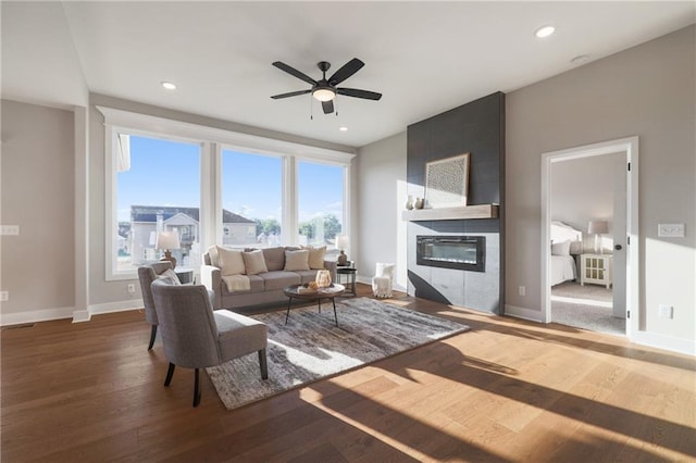 living room featuring a fireplace, ceiling fan, and wood-type flooring