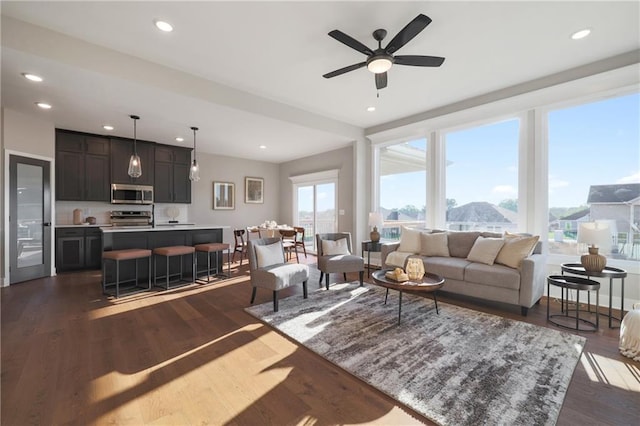 living room with ceiling fan and dark wood-type flooring