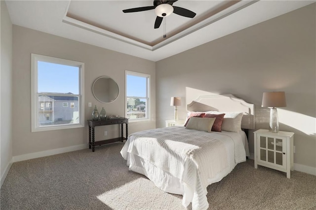 bedroom featuring ceiling fan, carpet floors, and a raised ceiling