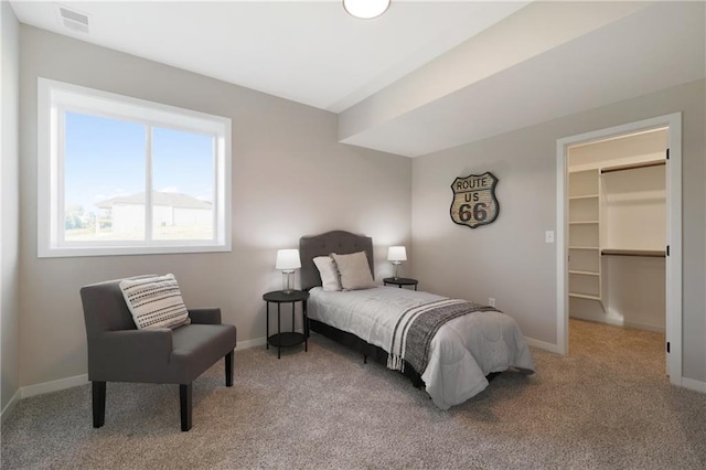 bedroom featuring a spacious closet, carpet floors, and a closet