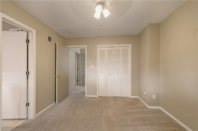 unfurnished bedroom with light carpet, ceiling fan, and a closet