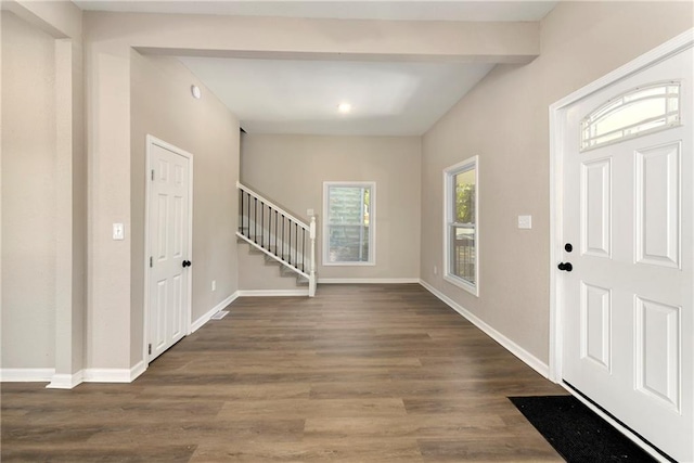 entryway with beam ceiling and dark hardwood / wood-style flooring