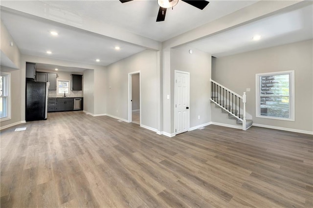 unfurnished living room with sink, ceiling fan, and dark hardwood / wood-style flooring