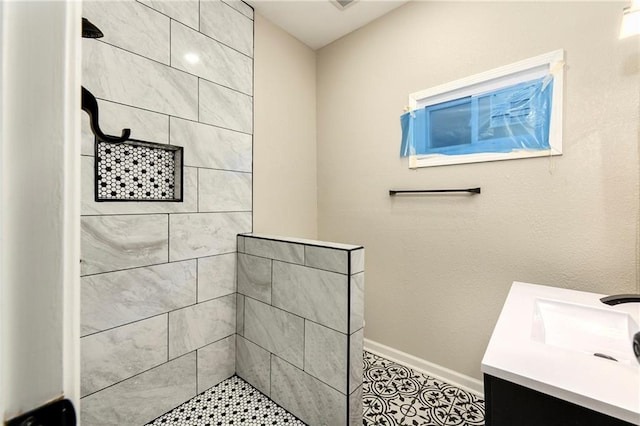 bathroom with vanity and tiled shower