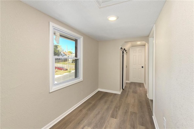 hallway featuring a barn door and wood-type flooring