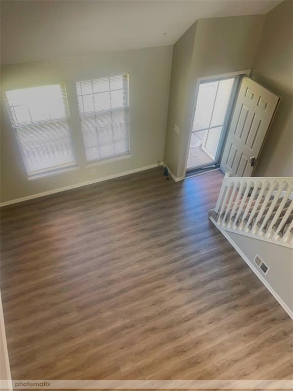 interior space with dark hardwood / wood-style flooring and lofted ceiling