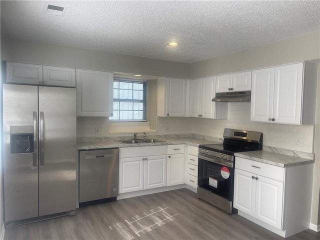 kitchen with white cabinets, dark hardwood / wood-style floors, sink, and stainless steel appliances