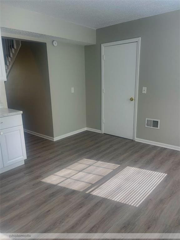 unfurnished room featuring light hardwood / wood-style floors and a textured ceiling