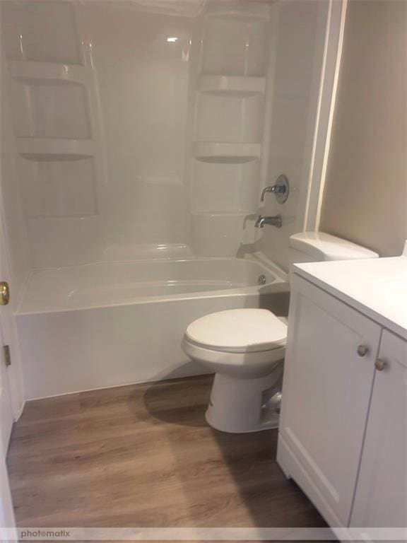 full bathroom featuring hardwood / wood-style floors, vanity, toilet, and shower / bathing tub combination