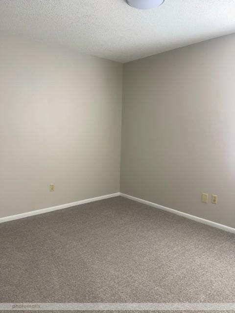 unfurnished room featuring carpet flooring and a textured ceiling