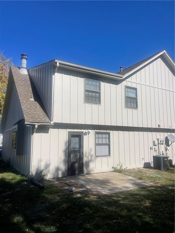 rear view of property featuring a patio area, a yard, and central AC unit