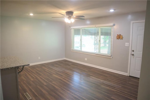 unfurnished living room featuring dark wood-type flooring and ceiling fan