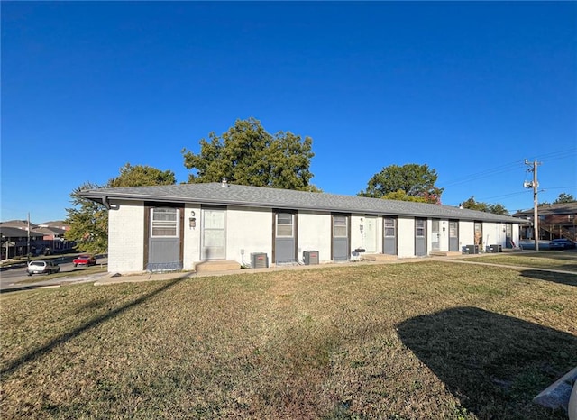 ranch-style home featuring a front yard and central AC unit