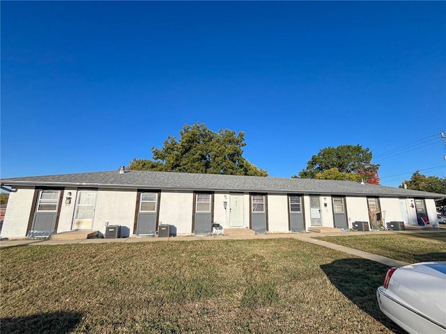 ranch-style home featuring cooling unit and a front lawn