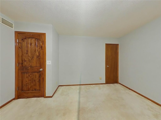 spare room featuring carpet flooring and a textured ceiling