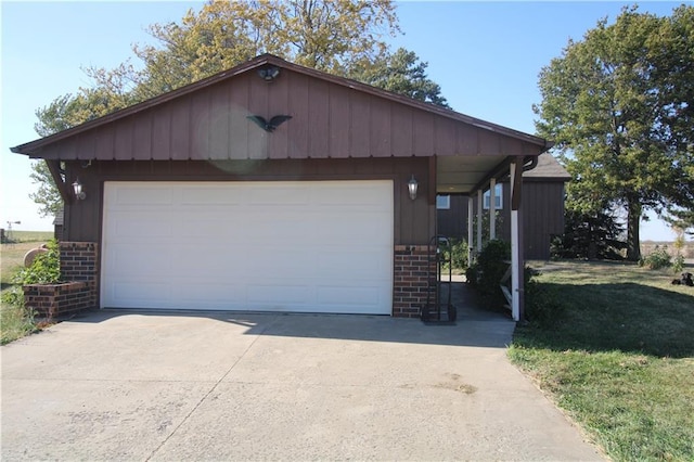 view of front facade with brick siding, an outdoor structure, a detached garage, and a front yard