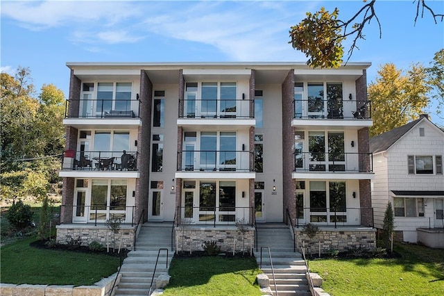 view of front facade featuring a front lawn and a balcony