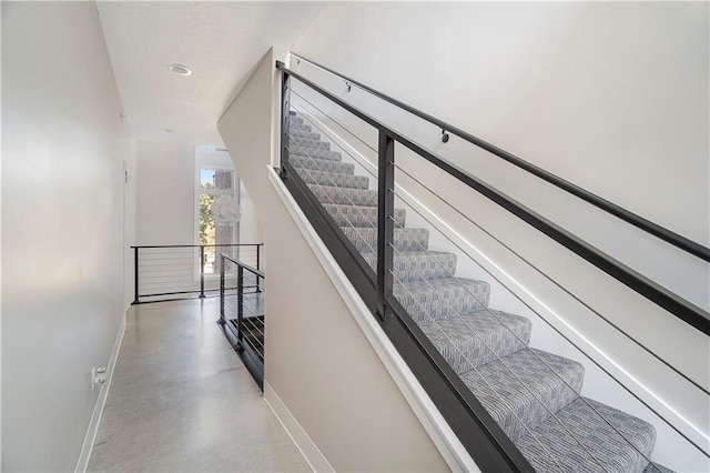 stairway with concrete flooring