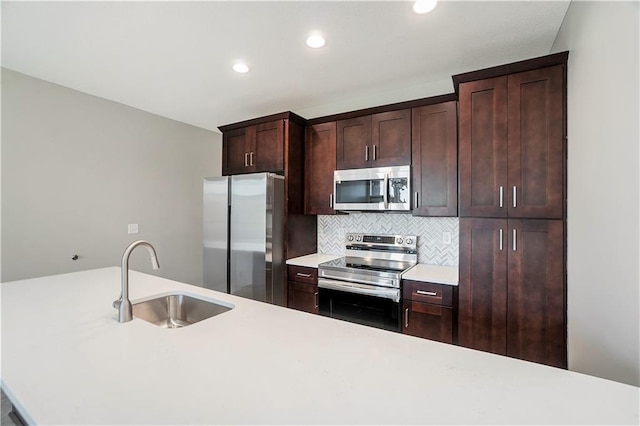 kitchen featuring dark brown cabinets, stainless steel appliances, sink, and backsplash