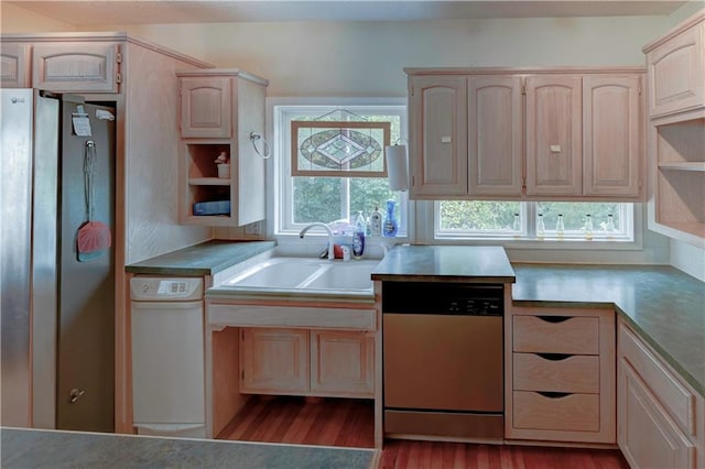 kitchen with appliances with stainless steel finishes, sink, and light hardwood / wood-style floors