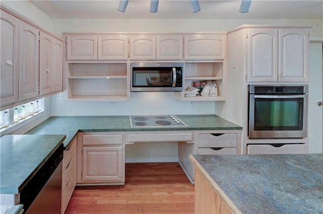 kitchen featuring backsplash, appliances with stainless steel finishes, light brown cabinetry, and light wood-type flooring