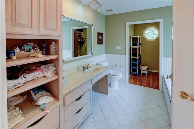 bathroom featuring vanity, toilet, and tile patterned flooring