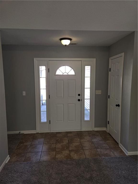 foyer with dark tile patterned flooring