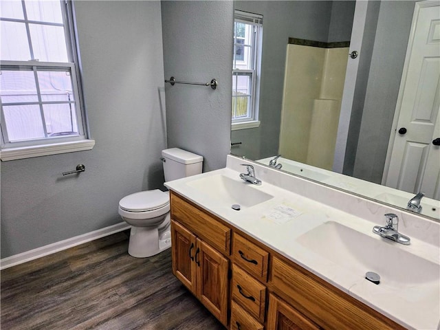 bathroom with vanity, hardwood / wood-style flooring, toilet, and walk in shower