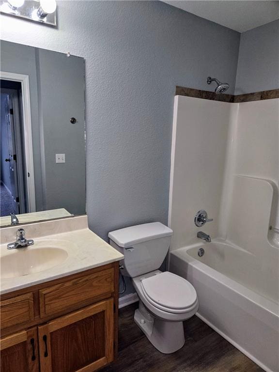 full bathroom featuring vanity, wood-type flooring,  shower combination, and toilet