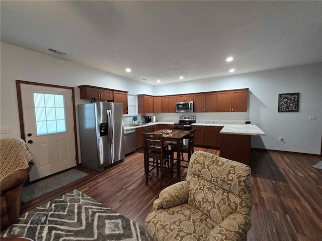 kitchen featuring appliances with stainless steel finishes, dark hardwood / wood-style floors, and a kitchen island