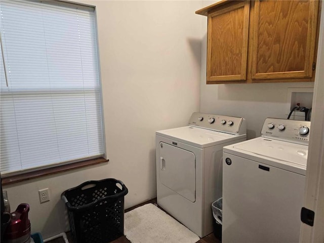 clothes washing area featuring washer and dryer and cabinets