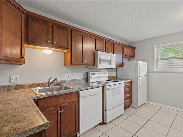 kitchen with sink, light tile patterned floors, and white appliances