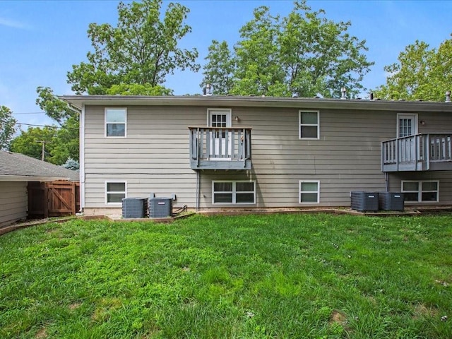 back of house with a balcony, cooling unit, and a lawn