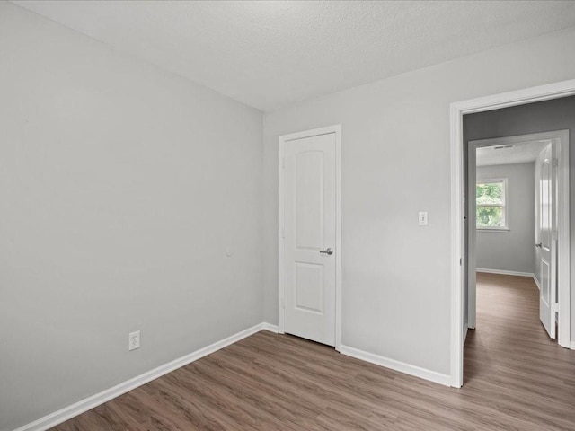 empty room featuring wood-type flooring and a textured ceiling