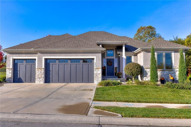 prairie-style house featuring a garage and a front lawn