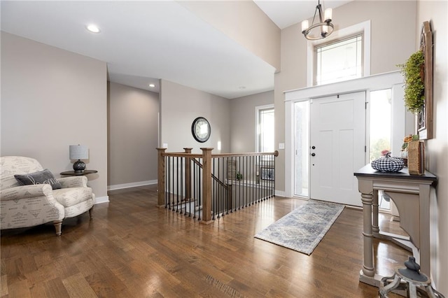 entrance foyer featuring an inviting chandelier and dark wood-type flooring