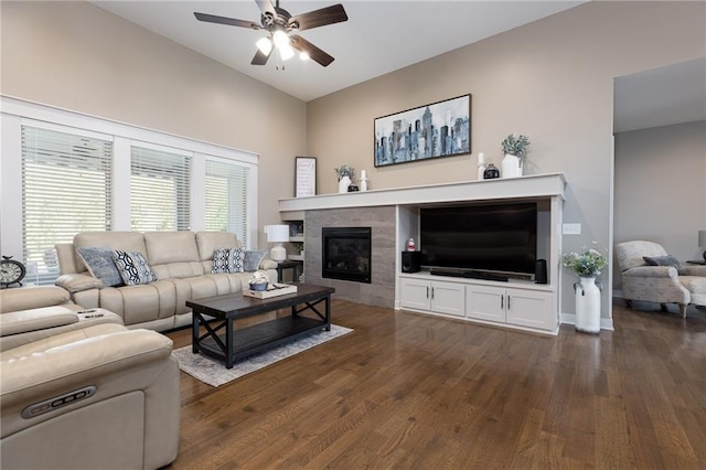 living room featuring dark wood-type flooring, a tile fireplace, and ceiling fan