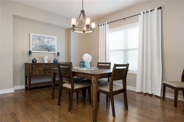 dining area with dark wood-type flooring and a chandelier