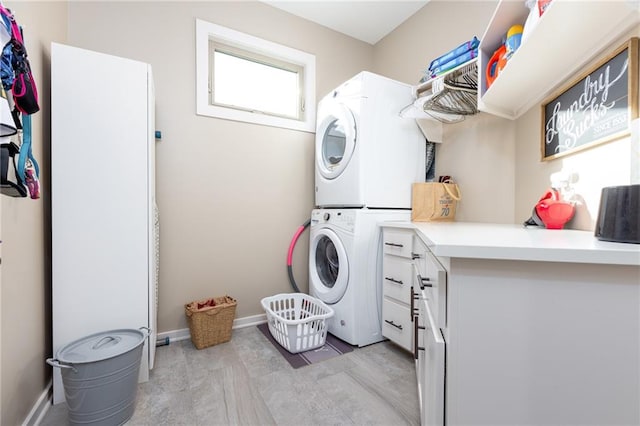 laundry area with stacked washing maching and dryer and light hardwood / wood-style floors