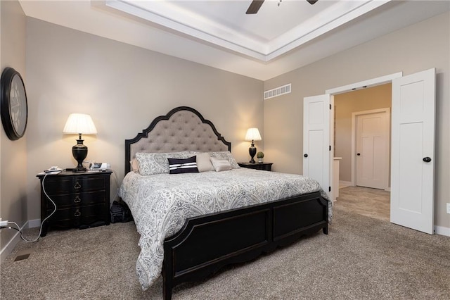 bedroom featuring carpet floors, a tray ceiling, and ceiling fan