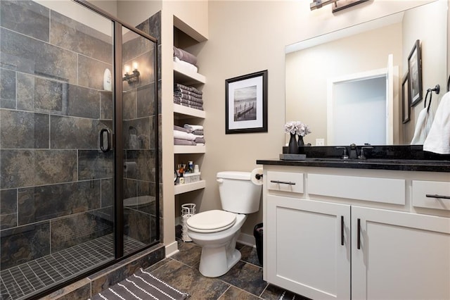 bathroom featuring a shower with door, vanity, and toilet