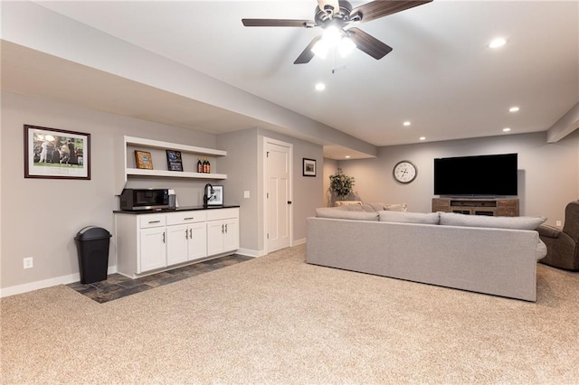 carpeted living room with ceiling fan