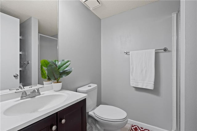 bathroom with toilet, an enclosed shower, a textured ceiling, and vanity