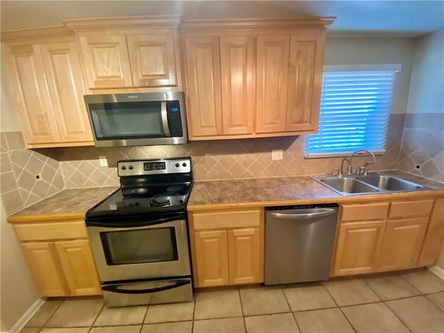 kitchen with light tile patterned flooring, stainless steel appliances, sink, and backsplash