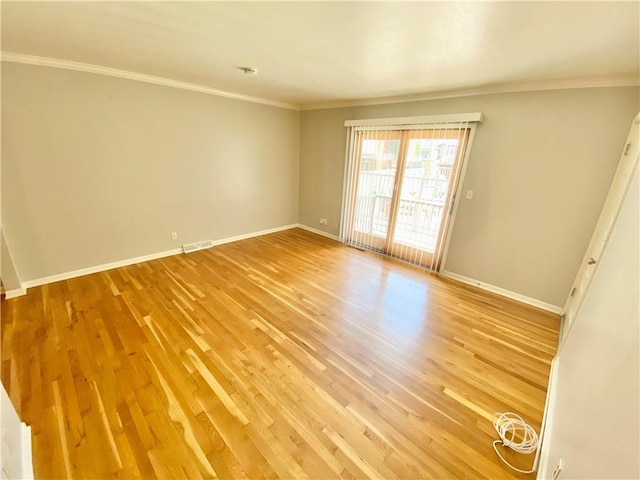 empty room featuring light hardwood / wood-style floors and ornamental molding